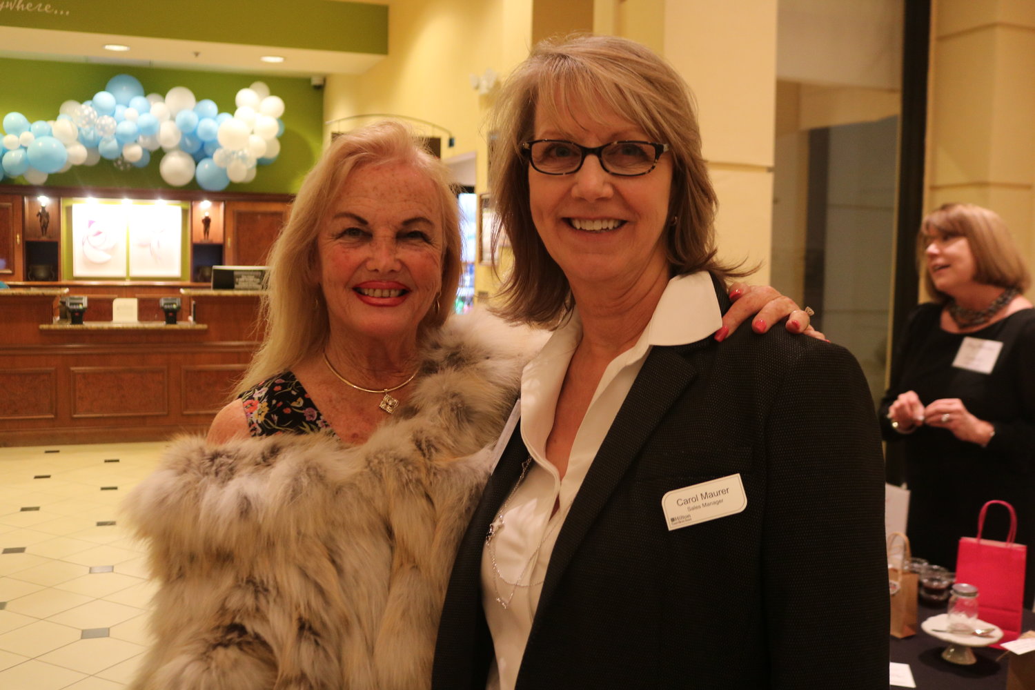 1.	Leigh Cort and Carol Maurer pose at the Hilton Garden Inn lobby, Nov. 18, for the Women’s Food Alliance monthly event, hosted by Maurer, herself, and her catering company, Sawgrass Events.